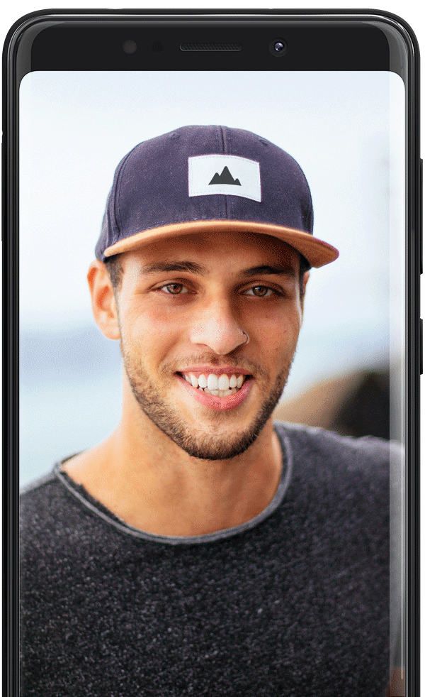 A selfie portrait of a guy with the see in background